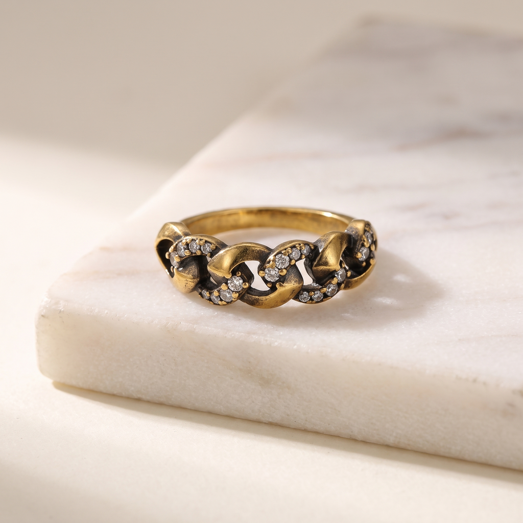 Vintage gold chain link ring, lying on white marble