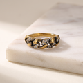Vintage gold chain link ring, lying on white marble