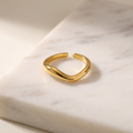 Adjustable wave open ring, lying on white marble