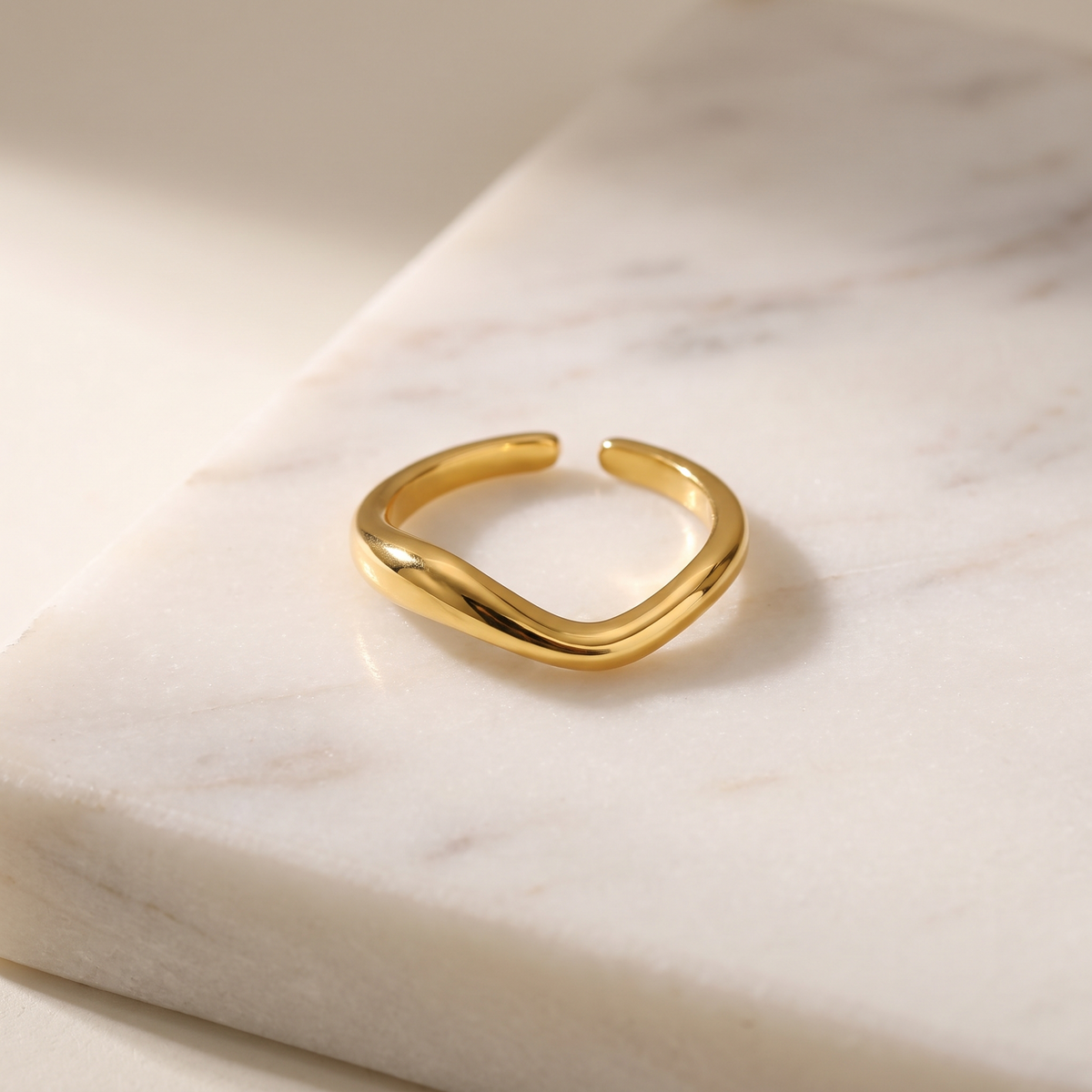 Adjustable wave open ring, lying on white marble