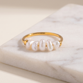 Freshwater pearl solitaire ring, lying on white marble