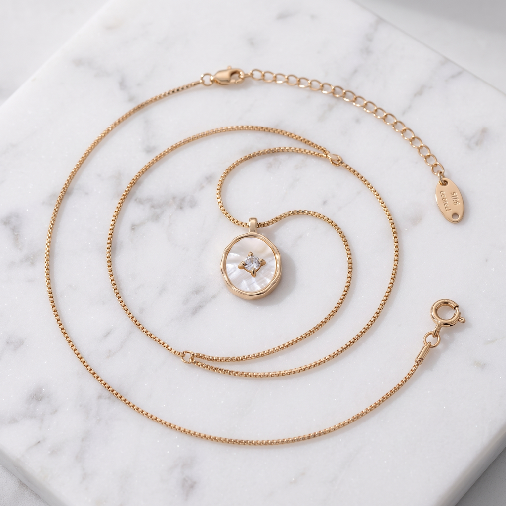 Mother-of-pearl shell pendant necklace in gold on white marble