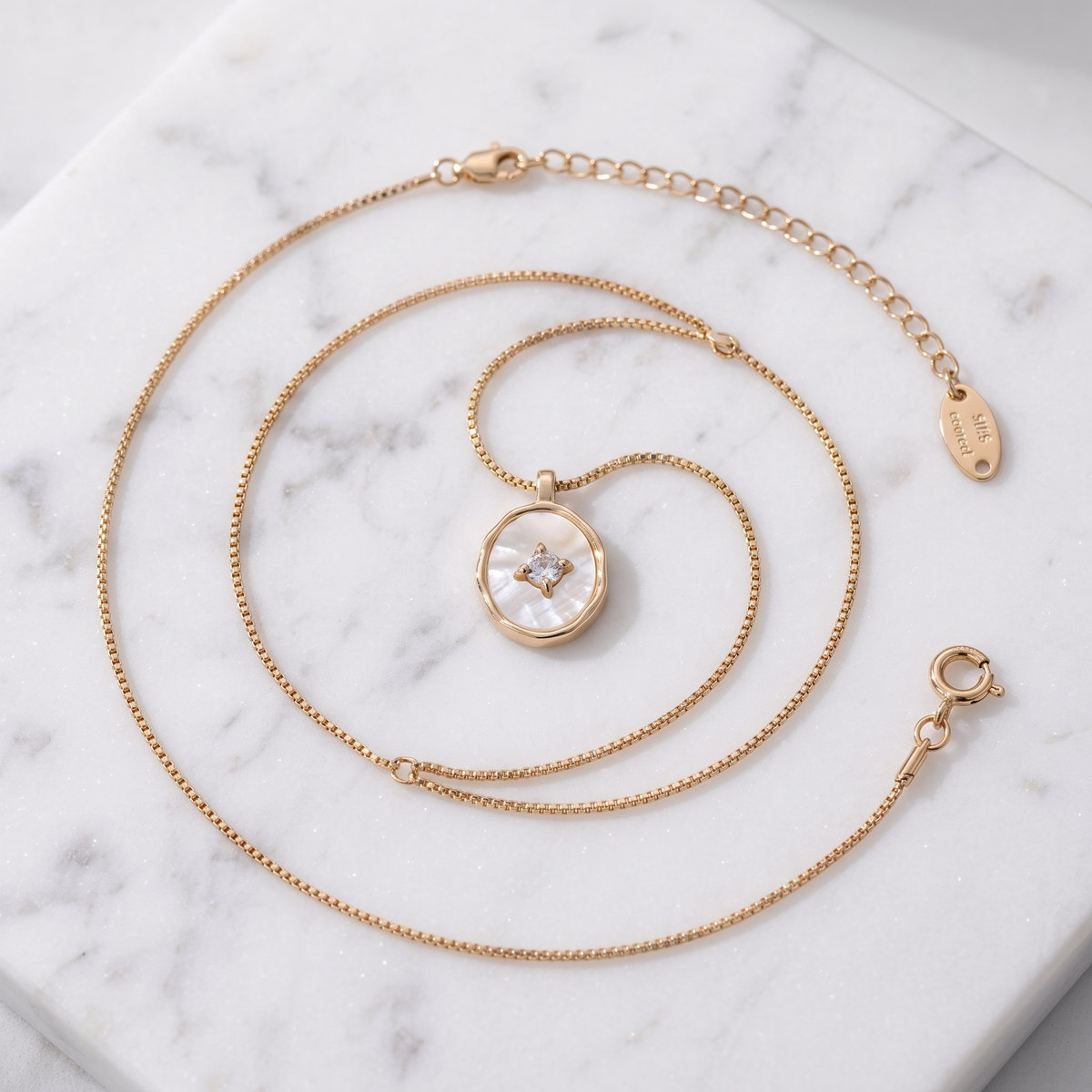 Mother-of-pearl shell pendant necklace in gold on white marble