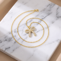 Gold pave bow pendant necklace on white marble