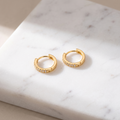 Zircon prong stud earrings on white marble