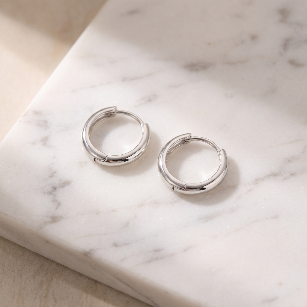 Sterling silver hoop earrings on white marble