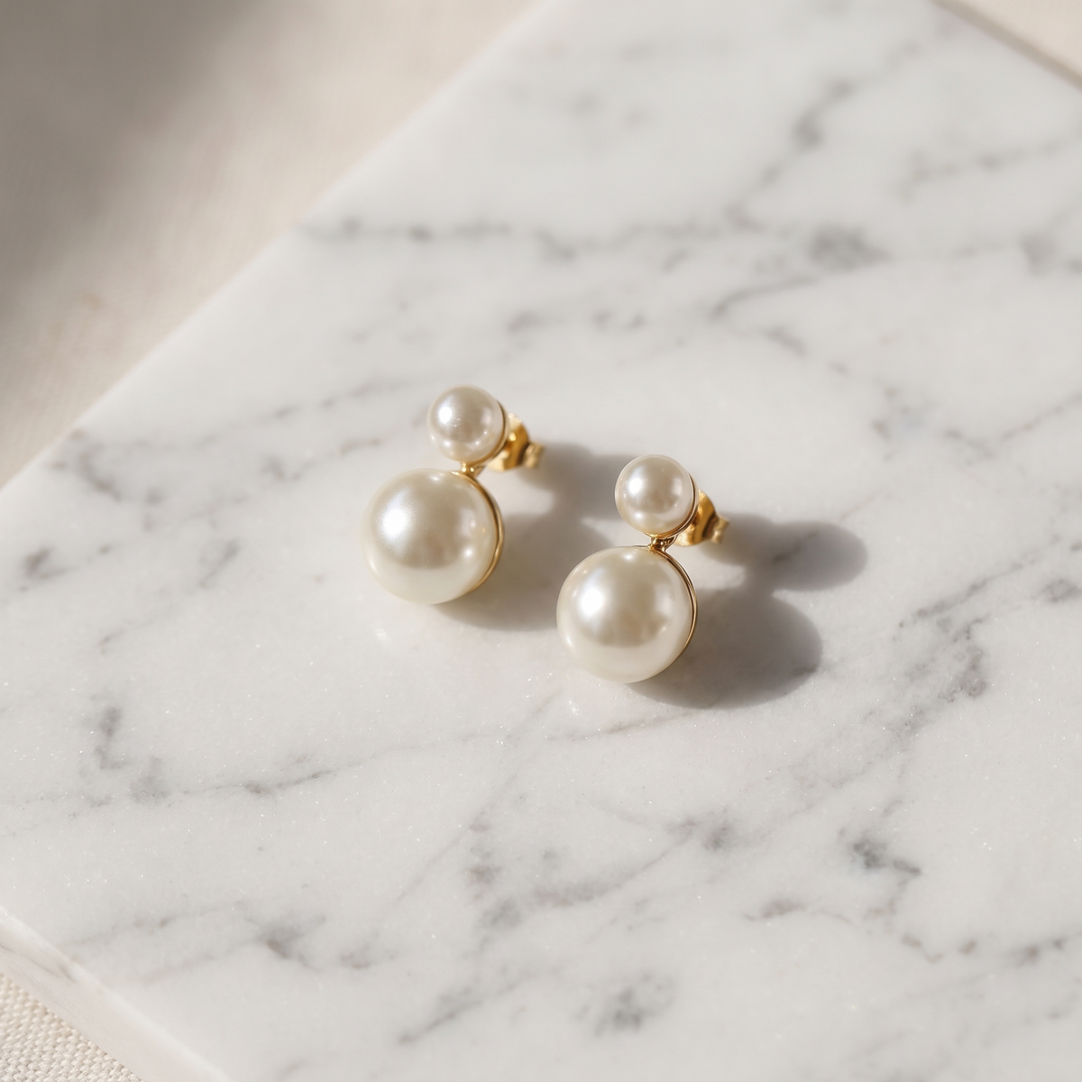 Vintage gold pearl drop earrings on white marble