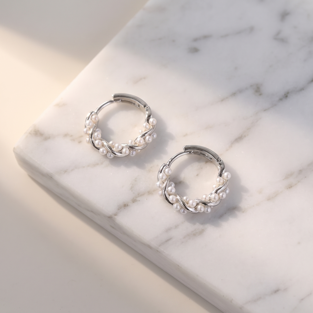 Irregular pearl hoop earrings on white marble