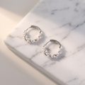 Irregular pearl hoop earrings on white marble