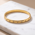 Gold starry zircon bangle on white marble
