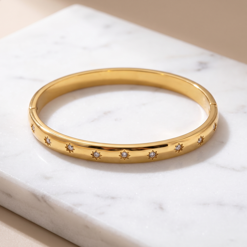 Gold starry zircon bangle on white marble