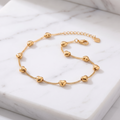 Gold heart link bracelet on white marble